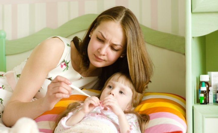 Foto von einer Mutter, die bei ihrem Kind Fieber misst